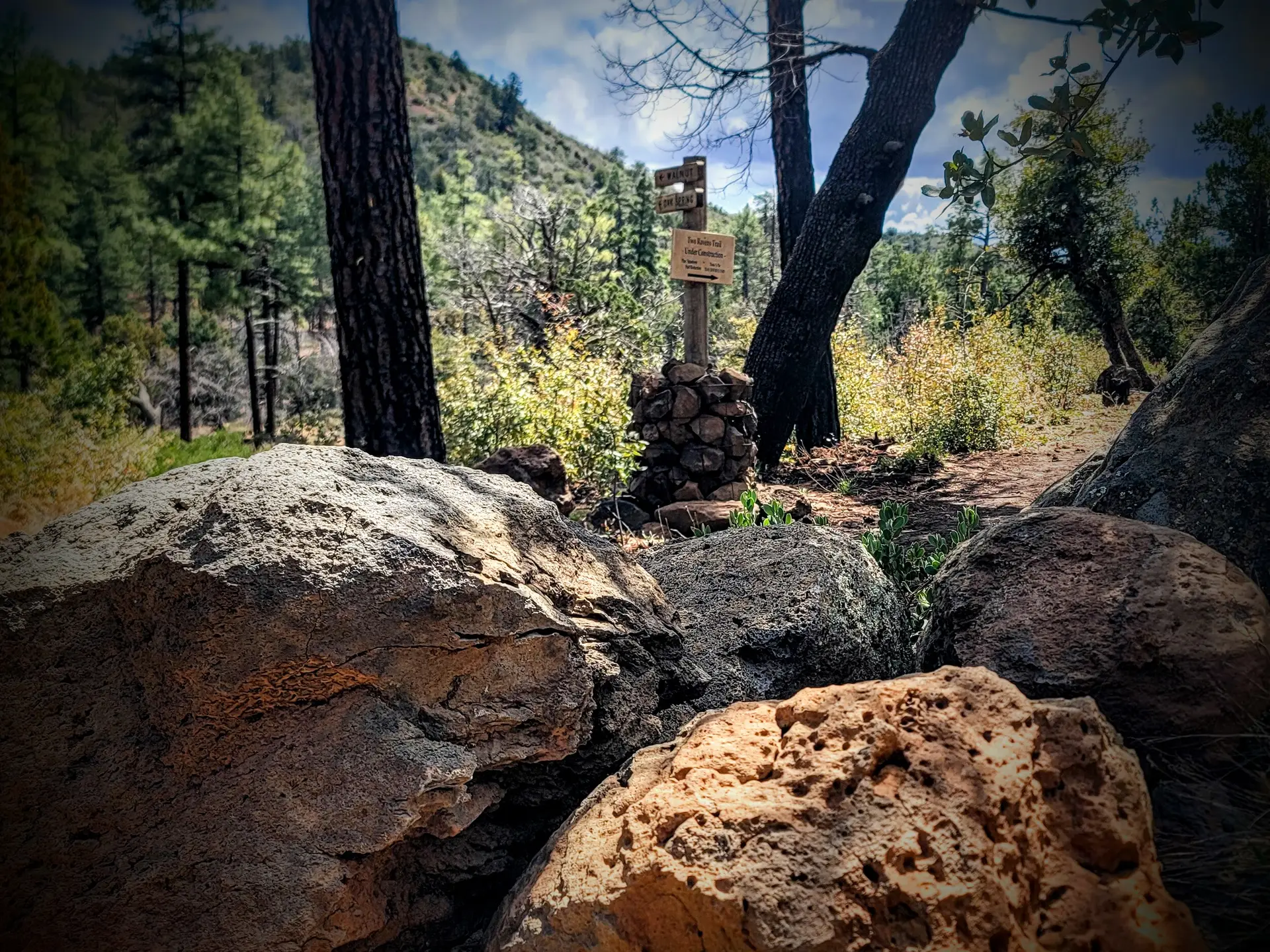 Rocks in foreground trail head sign in background